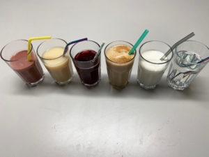 Sechs Gläser mit unterschiedlichen Getränken und Strohhalmen.