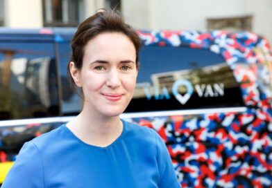 Portrait von Valerie von der Tann. Imm Hintergrund unscharf ein Umriss eines Berlköönig-Fahrzeugs.