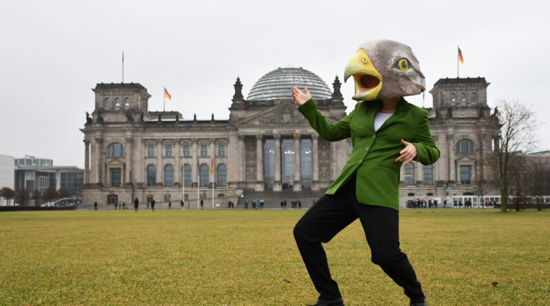Mensch mit Adlerkopf vor dem Reichstag in Berlin.
