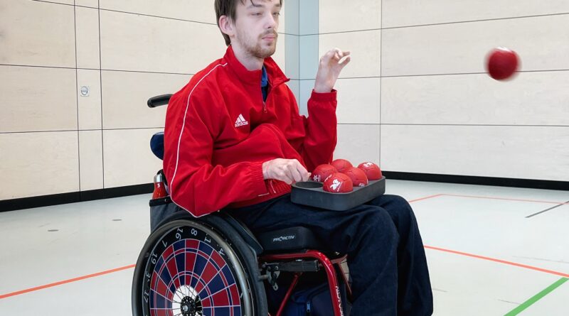 András Derenthal, im Rollstuhl, wirft eine Boccia-Kugel.