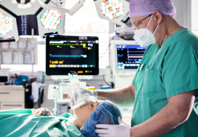 Eine liegende Patientin und rechts ein Narkosearzt.