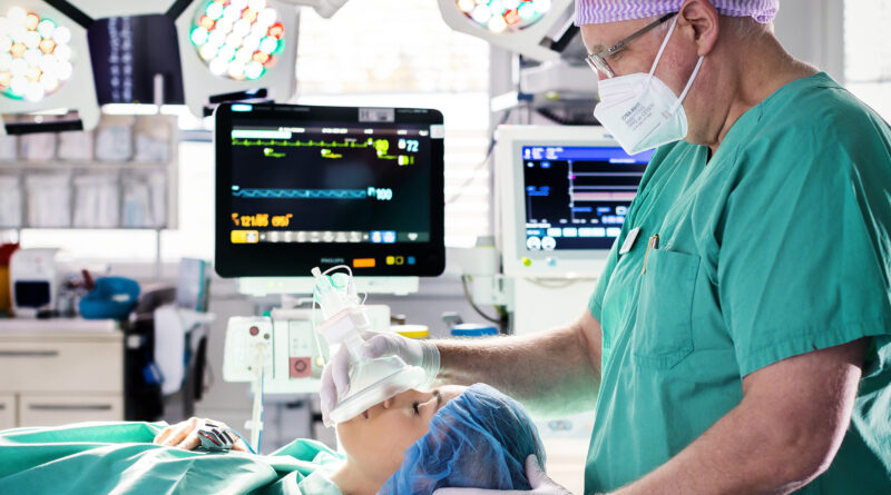 Eine liegende Patientin und rechts ein Narkosearzt.