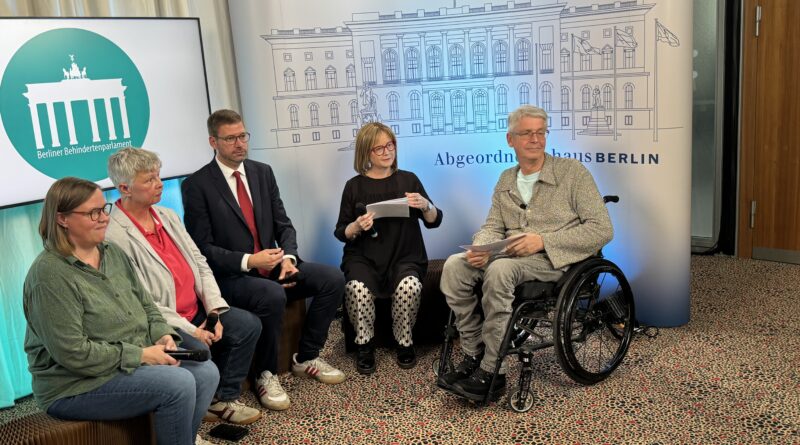 Gruppe von sechs Personen vor einer Leinwand des Abgeordnetenhauses Berlin